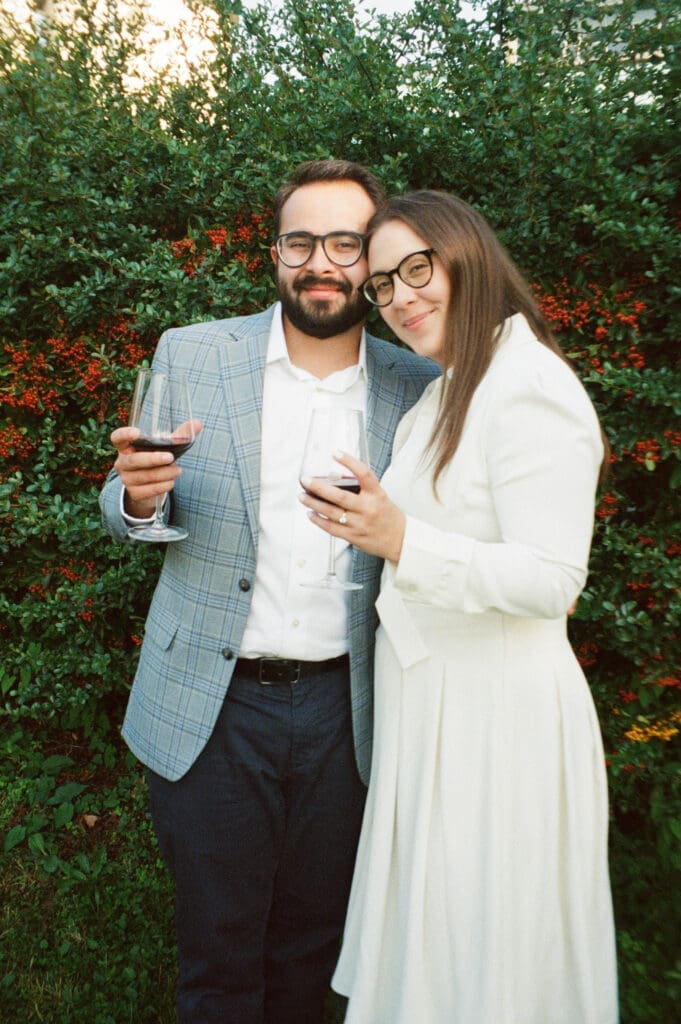 Film photograph of a couple holding red wine during a winery tour as part of their wedding week celebration in Italy