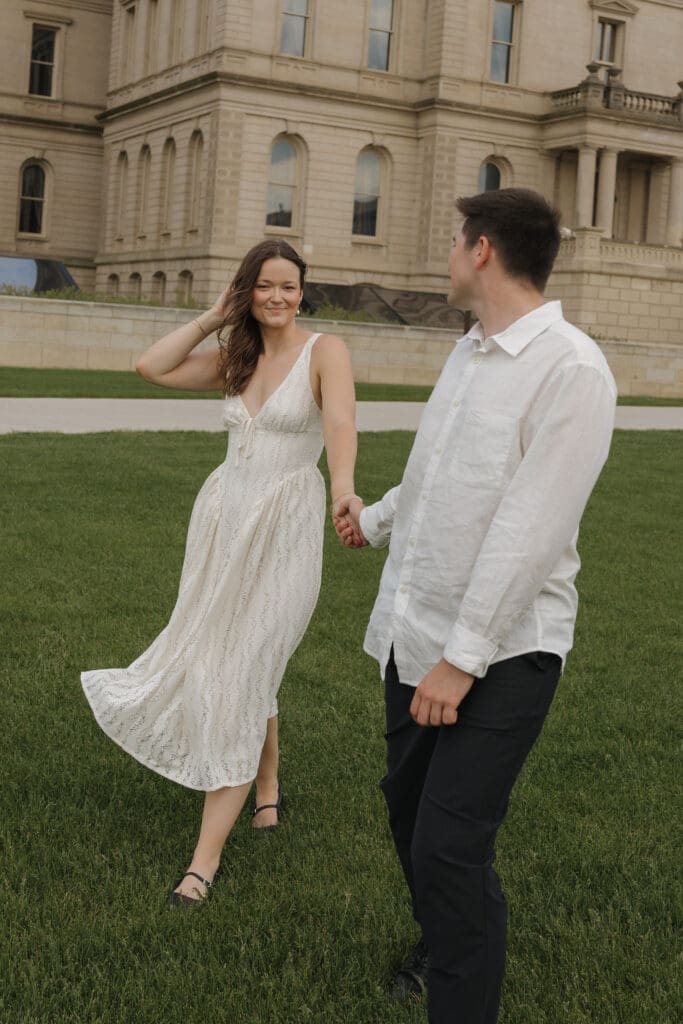 Couple holding hands during an engagement session at the Michigan State Capitol in Lansing, Michigan