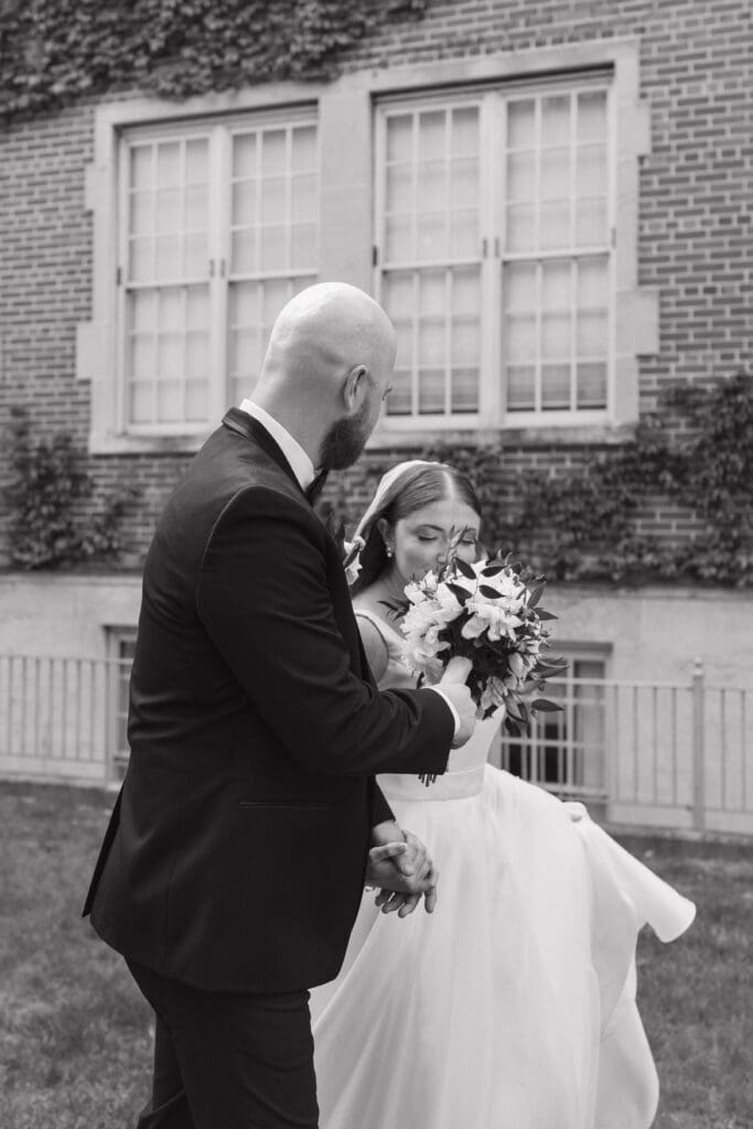 Bride and groom walking hand in hand during wedding portraits at Aquinas College in Grand Rapids, Michigan