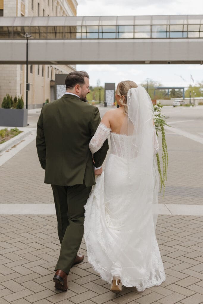Bride and groom walking together in downtown Grand Rapids, Michigan during wedding portraits