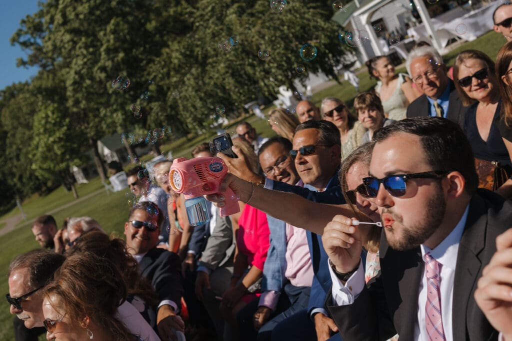 Wedding guests blowing bubbles during the bride and groom's ceremony exit at Walden Woods in Michigan. 