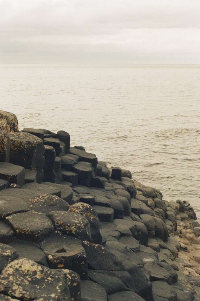 Basalt columns at Giant's Causeway along the Northern Ireland coastline, photographed on 35mm film in soft natural light.