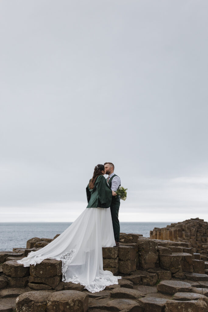 Bride and groom kissing on the basalt columns during their Giant's Causeway elopement on the Causeway Coast of Northern Ireland.