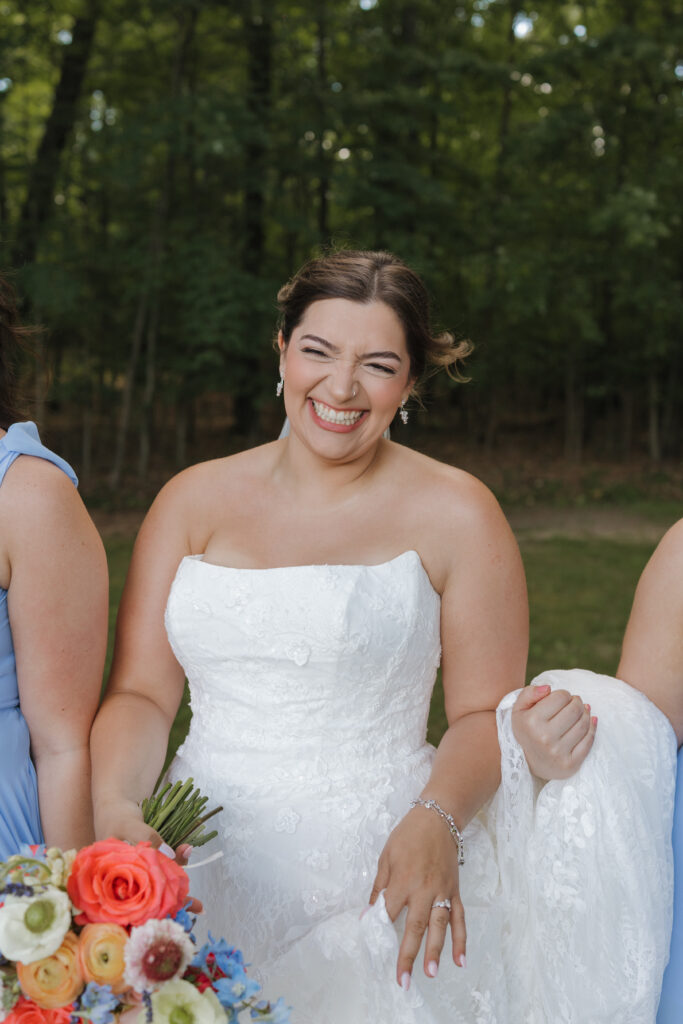 Candid portrait of a bride laughing while walking with her bridesmaids during wedding portraits at Waltman Lake Lodge in Michigan.